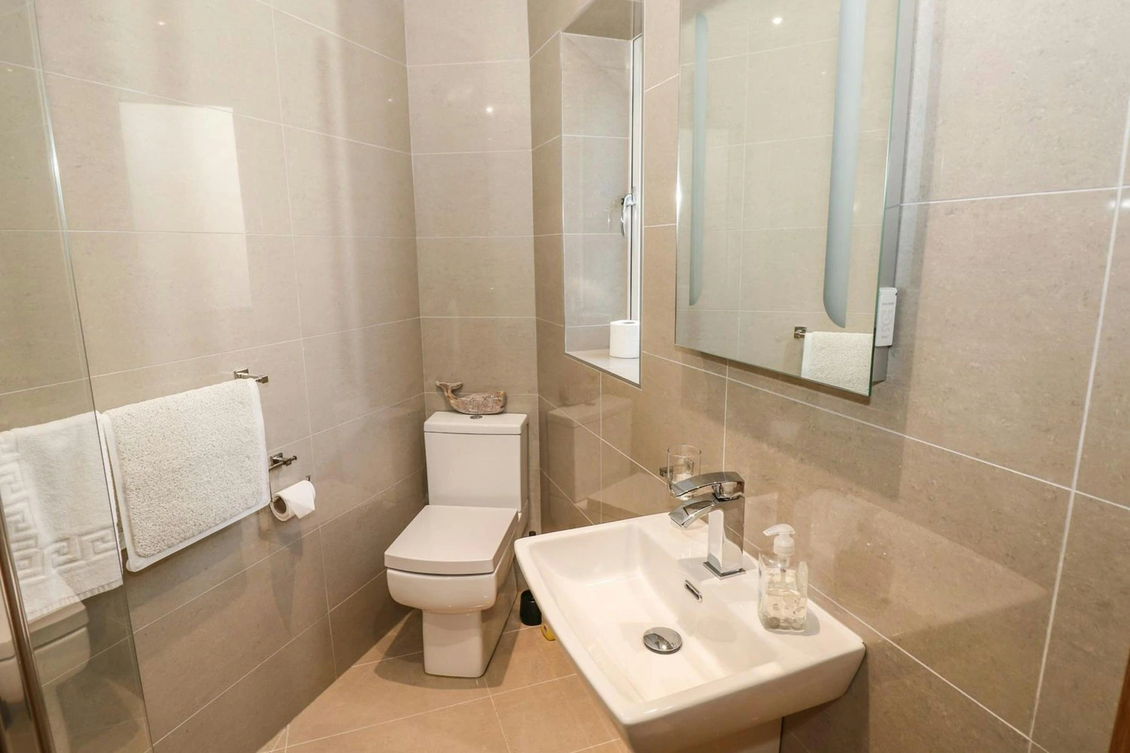 En suite shower room on the ground floor in Harmon Vale, shower, washbasin, shower and towels
