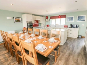 Kitchen/dining area in Harmon Vale with fitted units, table and 10 chairs, built-in oven, hob, microwave, kettle and toaster