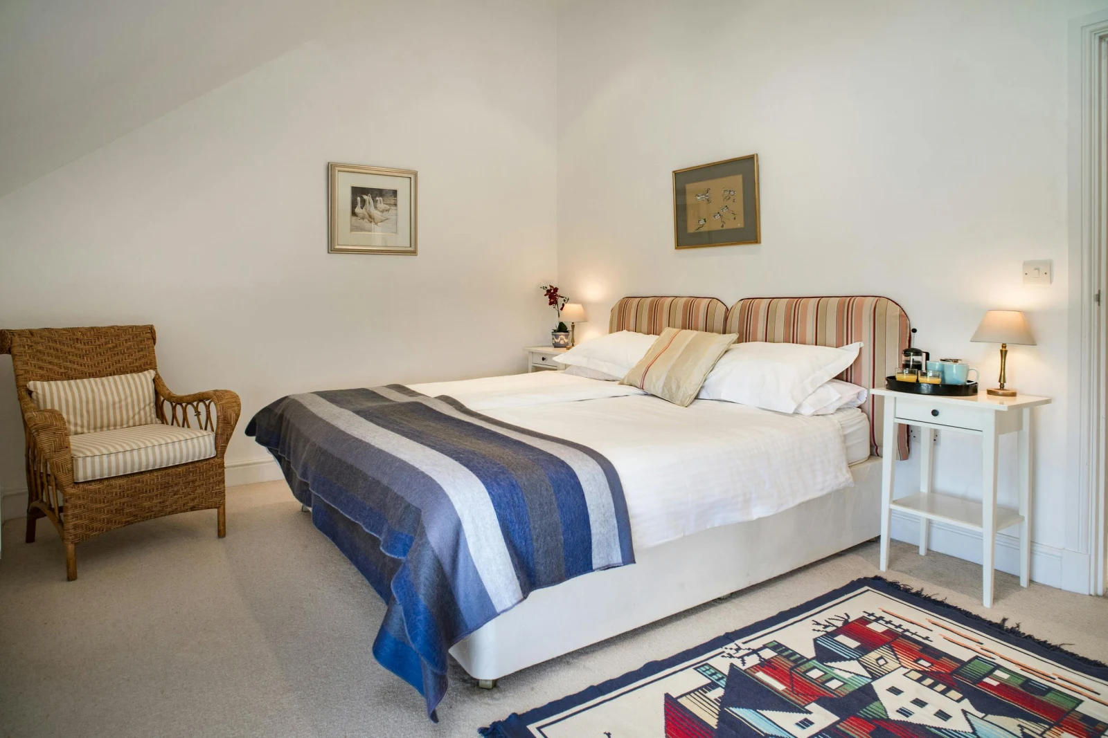 Bedroom with twin beds, bedside cabinets and lamps, chair