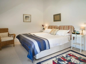 Bedroom with twin beds, bedside cabinets and lamps, chair