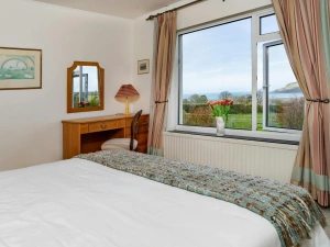 Bedroom with king size bed, dressing table and window with sea views