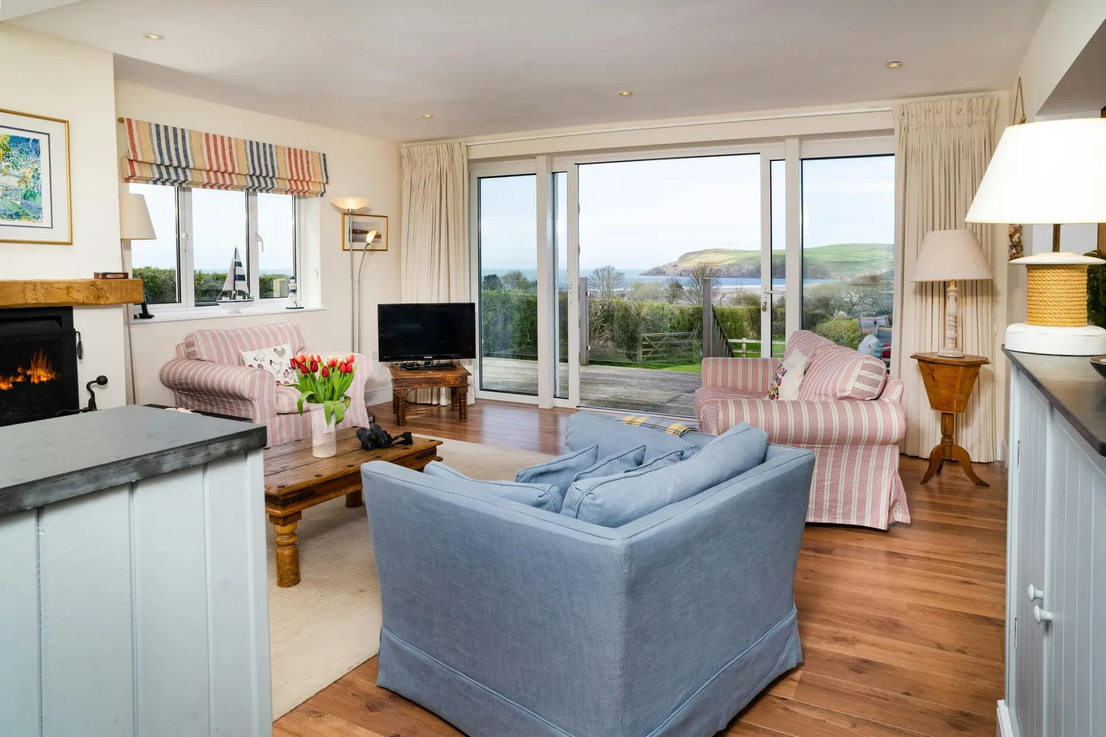 Living area at Dolawel with sofas, armchairs, tv and patio door leading to garden