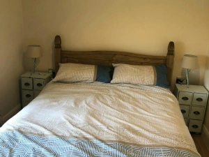 King size bed with bedside drawers and small lamps, picture above bed