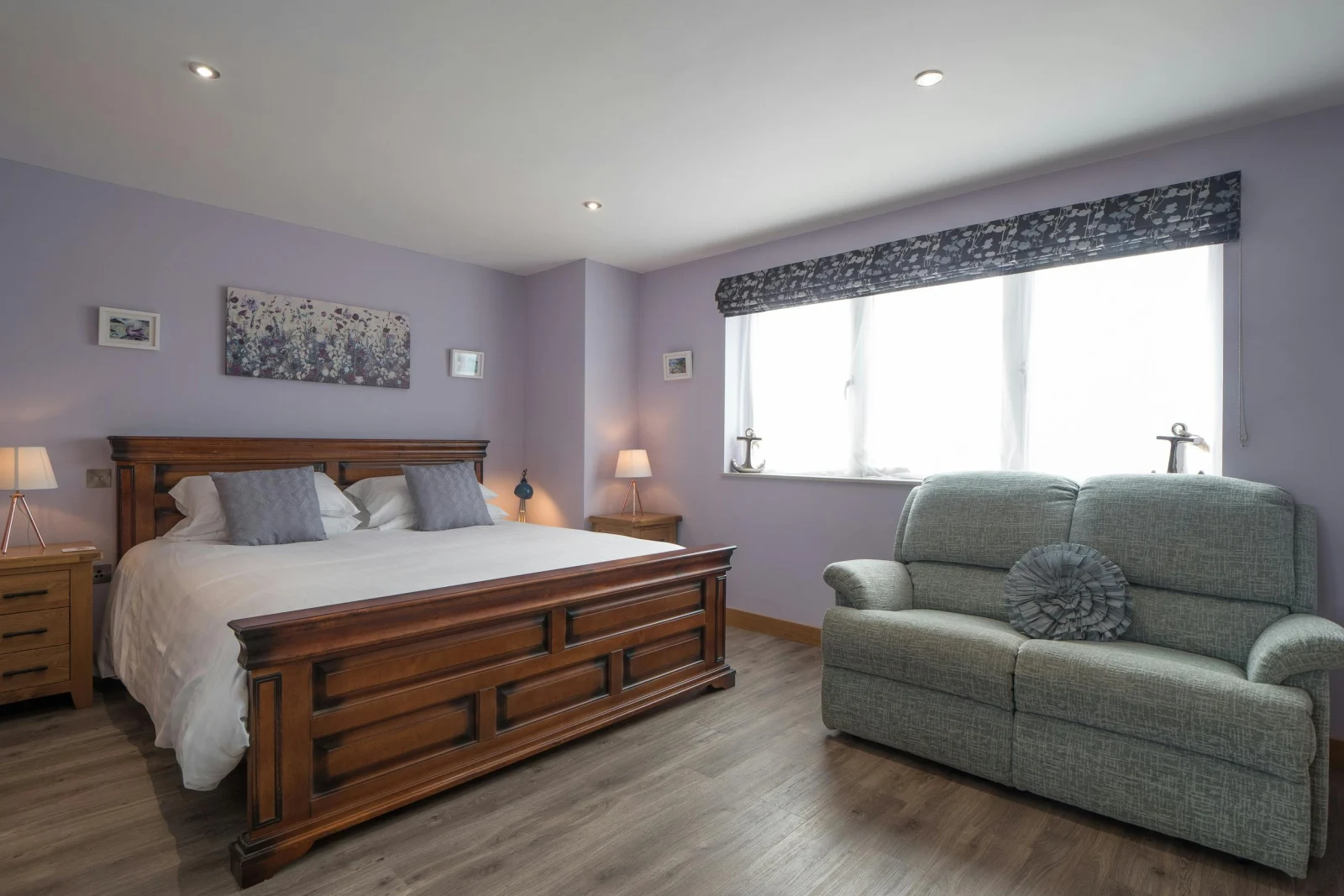 Bed with bedside cabinets and lamps and 2 seater sofa