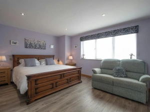 Bed with bedside cabinets and lamps and 2 seater sofa