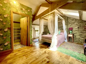 Four poster bed, bedside tables and lamps, chest of drawers, beamed ceiling