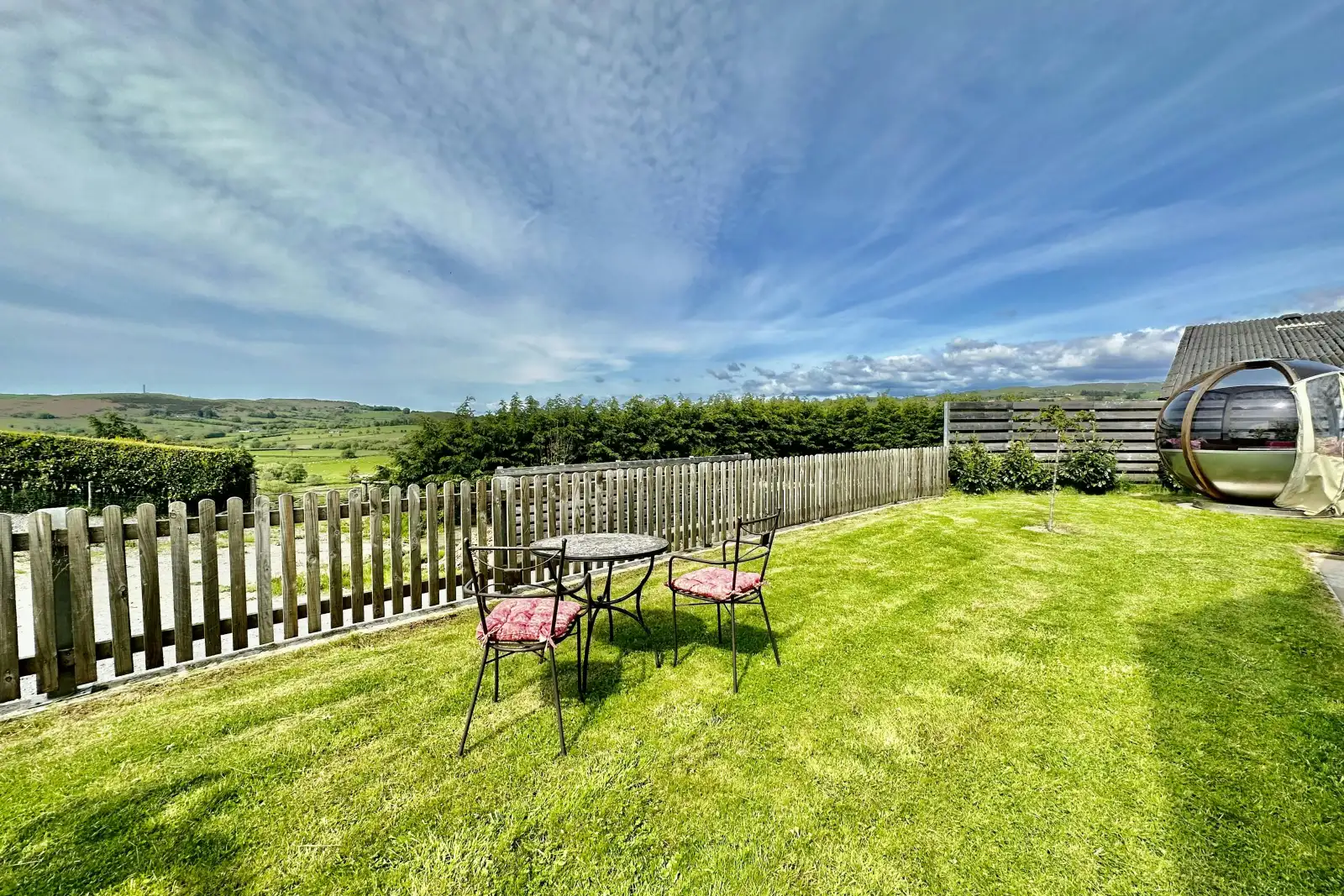 enclosed garden with outdoor table and chairs, blue skies