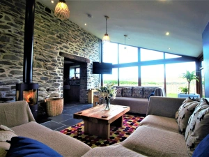 Corner sofa, sofa, coffee table with vase of flowers and wood burning stove