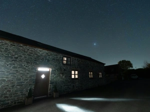 night time photo of the outside of the cottage, sky full of bright stars.