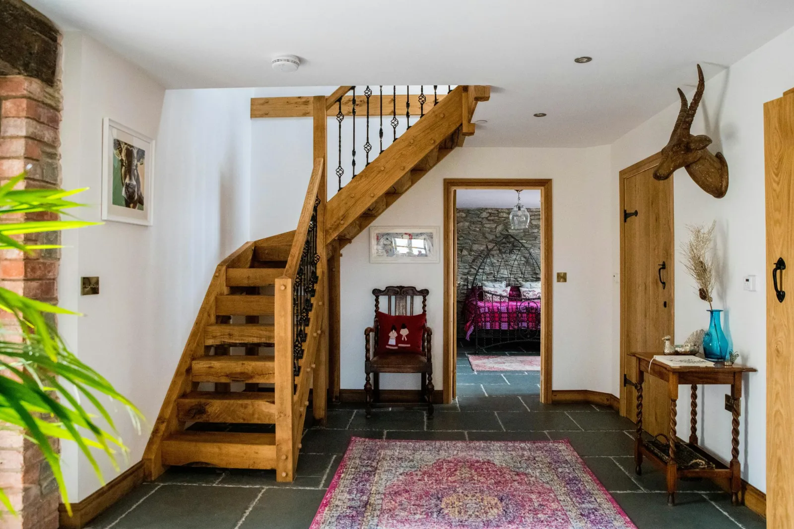 Staircase, large rug and table in the hallway