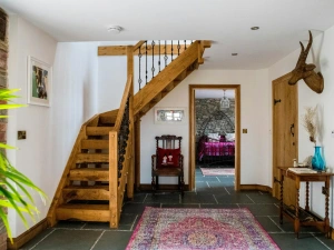 Staircase, large rug and table in the hallway