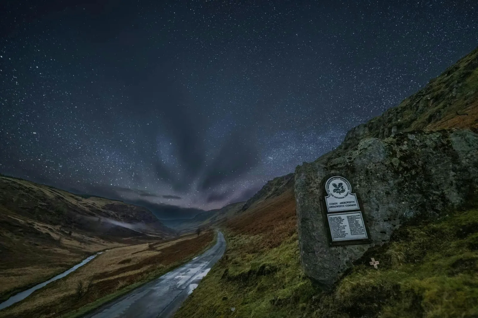 Starry sky over open countryside and National Trust sign