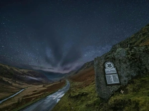 Starry sky over open countryside and National Trust sign