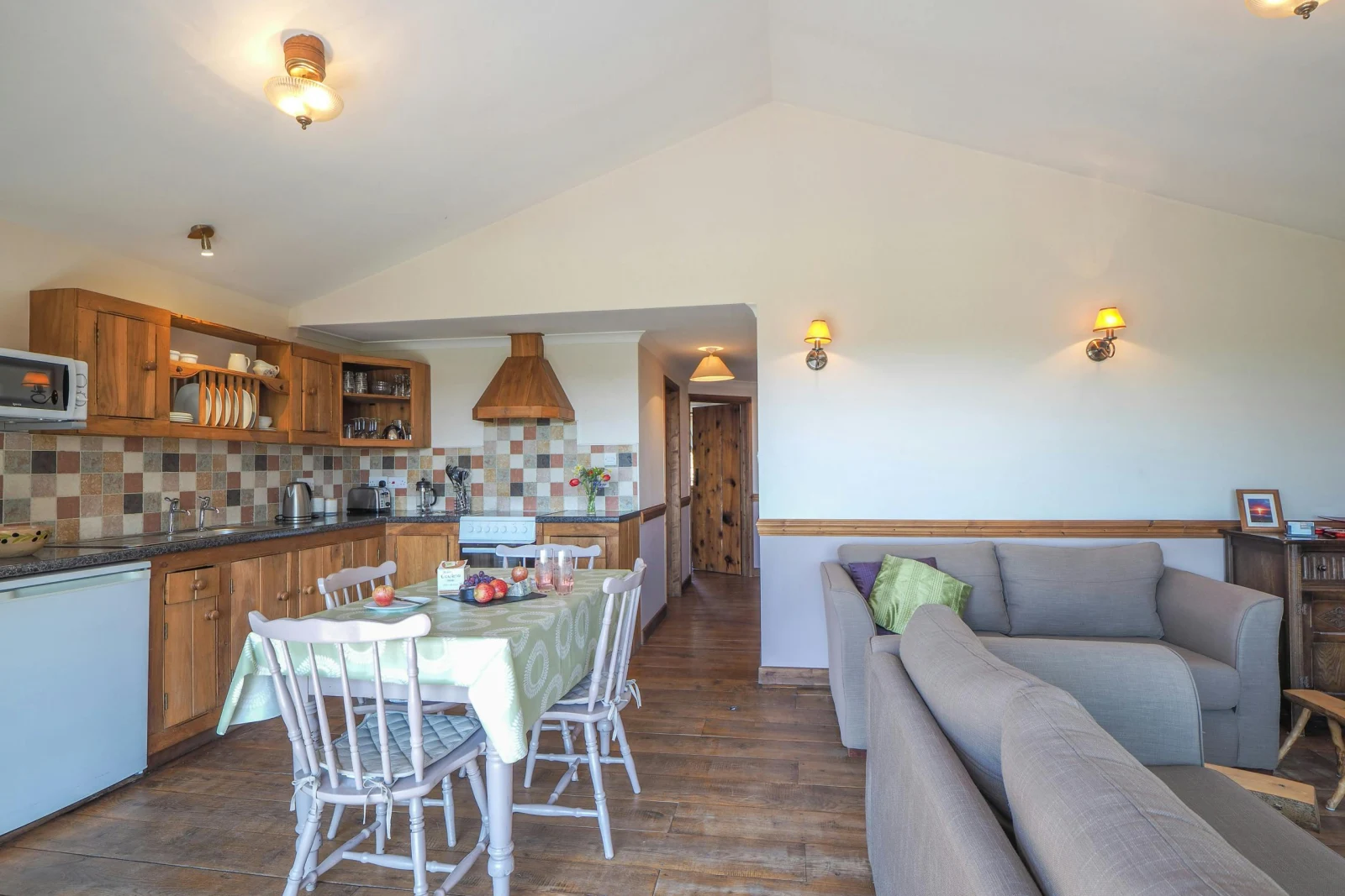 Kitchen and dining area with table and chairs, living area with sofas