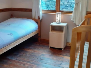 Caban Cynnes single bedroom with full size cot and bedside table