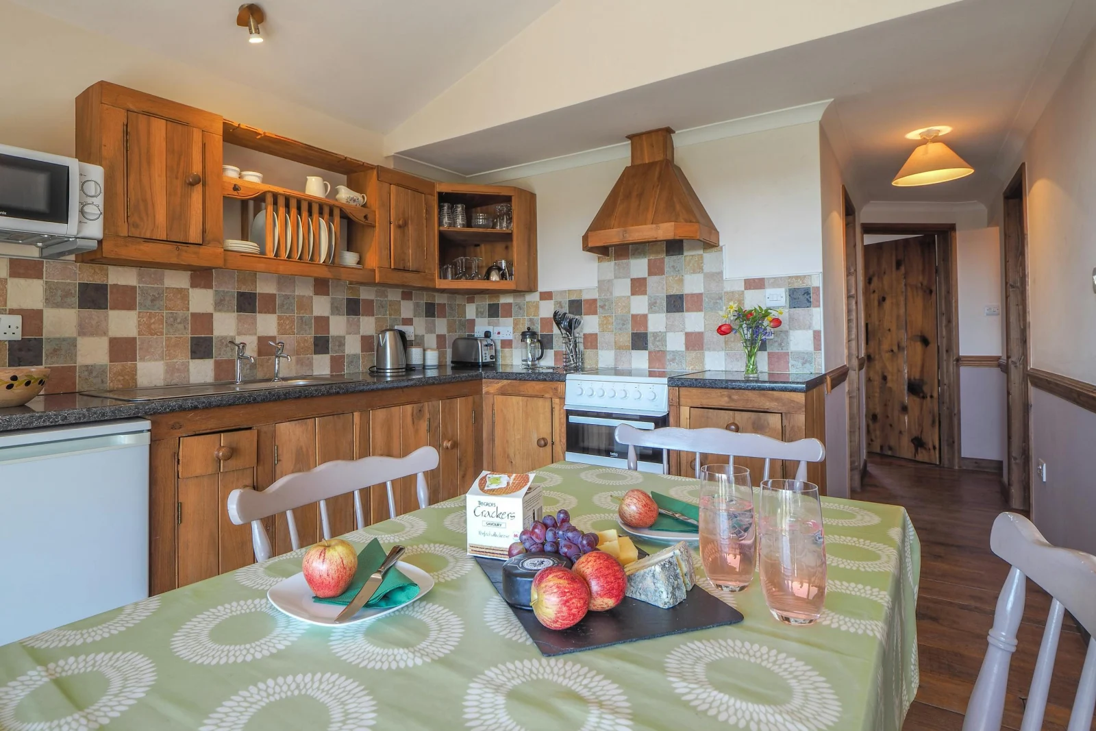 Kitchen and dining area, wooden kitchen units, cooker and cooker hood, dining table