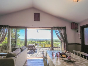 Dining area with table and chairs, double doors leading to patio with picnic bench
