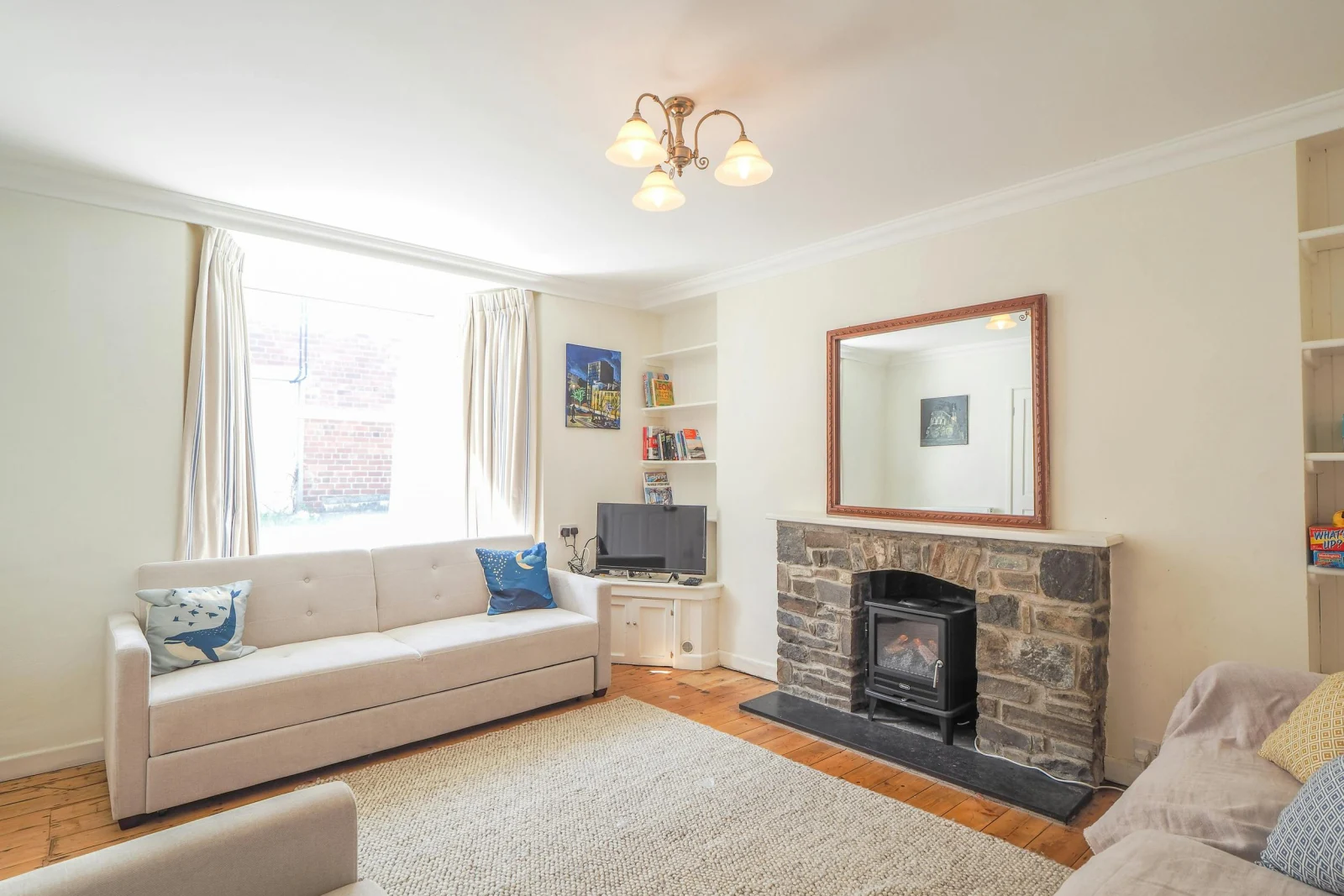 Sofas, fireplace and large mirror above, TV