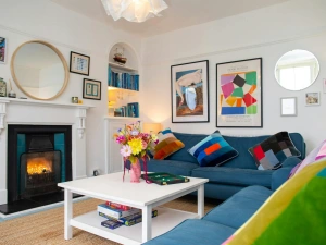 Sitting room with two large sofas, coffee table and open fire