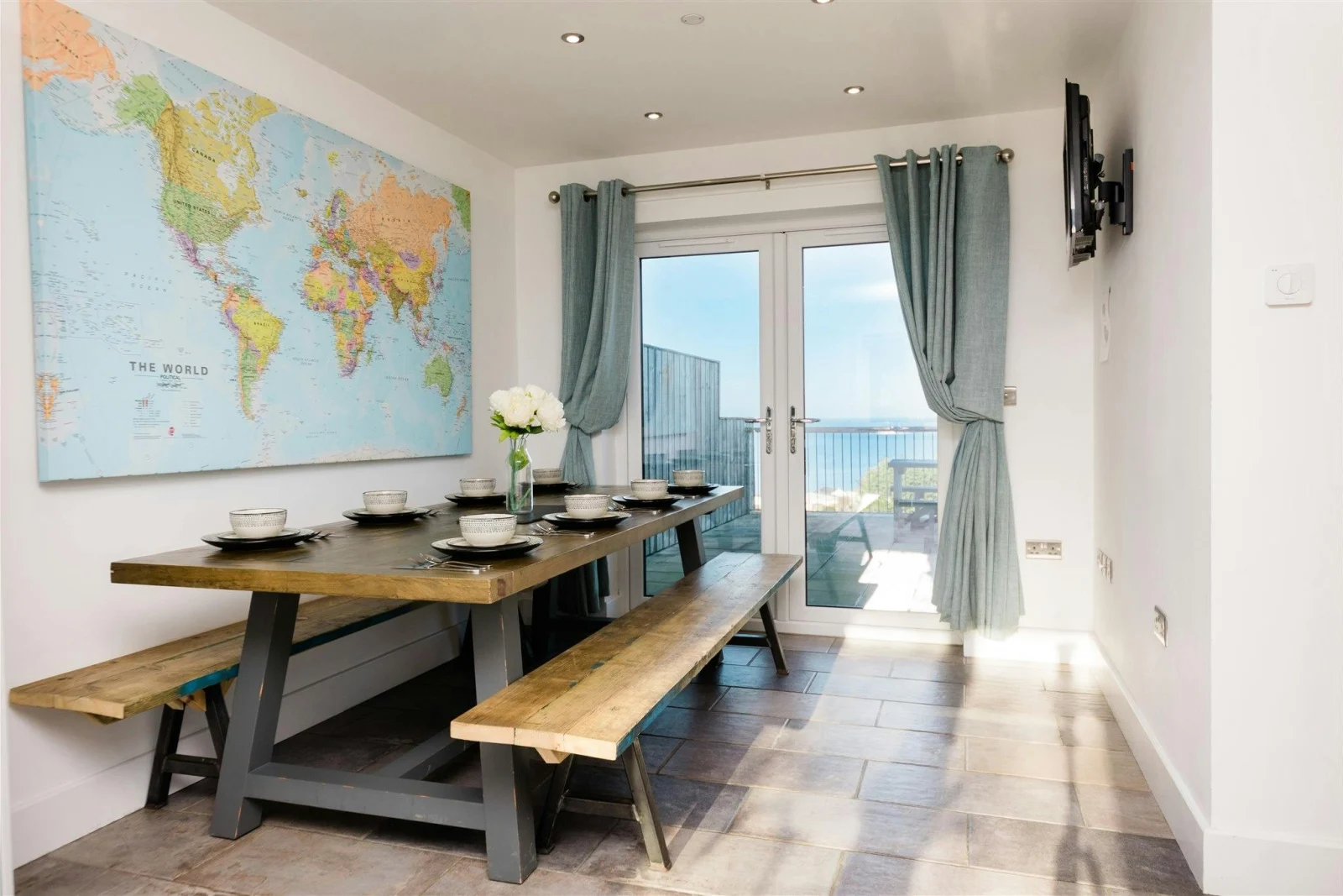 Map of the world on the wall, table and benches laid for lunch