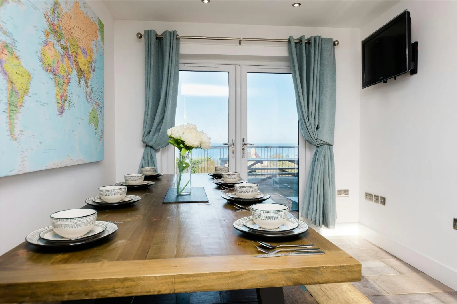 Map of the world on the wall, table and benches laid for lunch