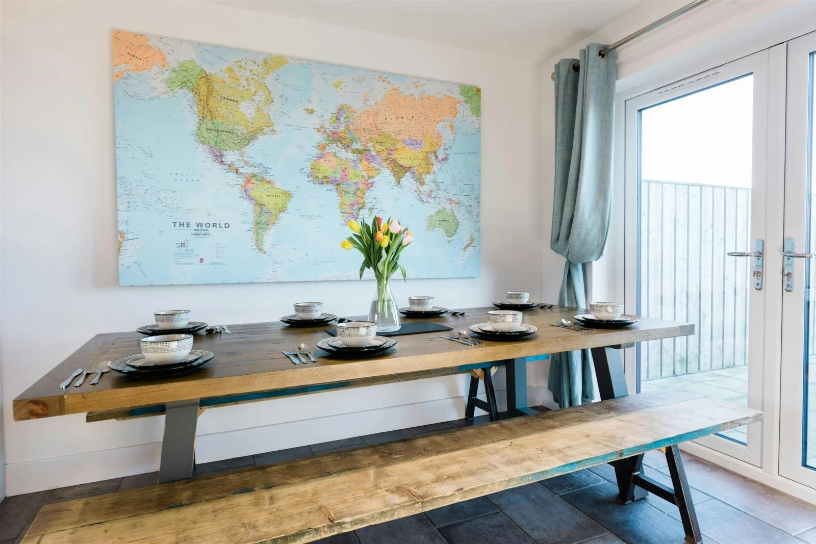 Map of the world on the wall, table and benches laid for lunch