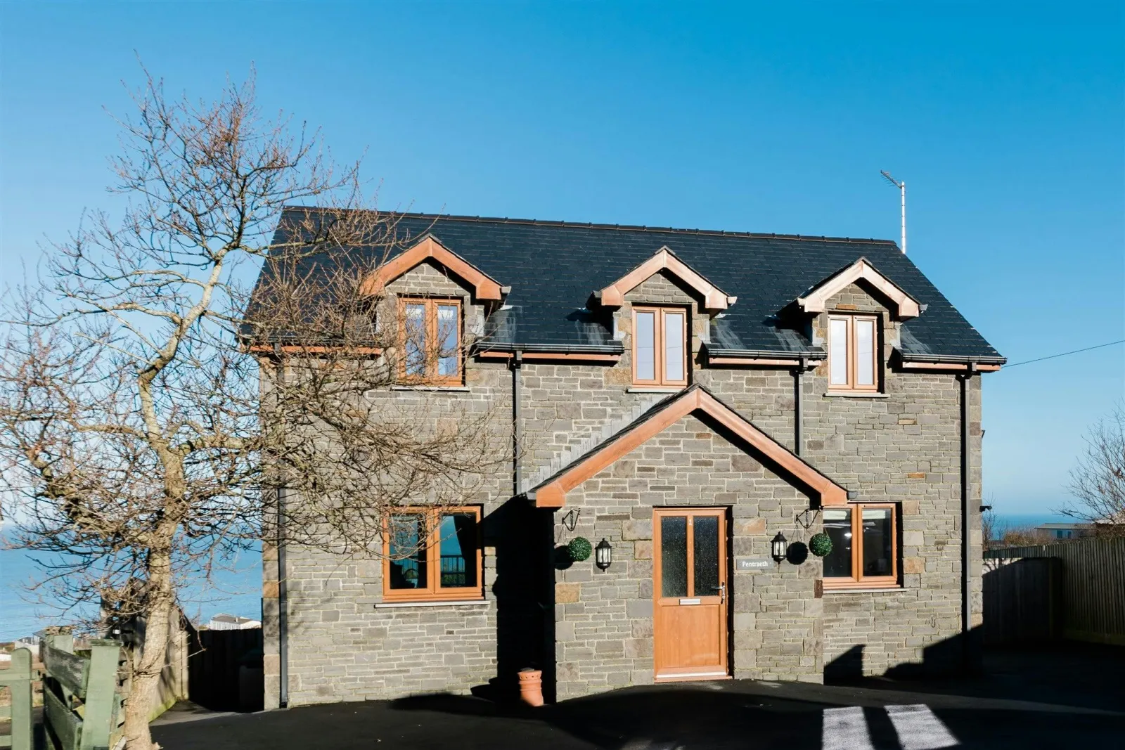 The outside of Pentraeth with tree beside the property