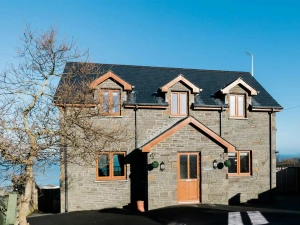 The outside of Pentraeth with tree beside the property