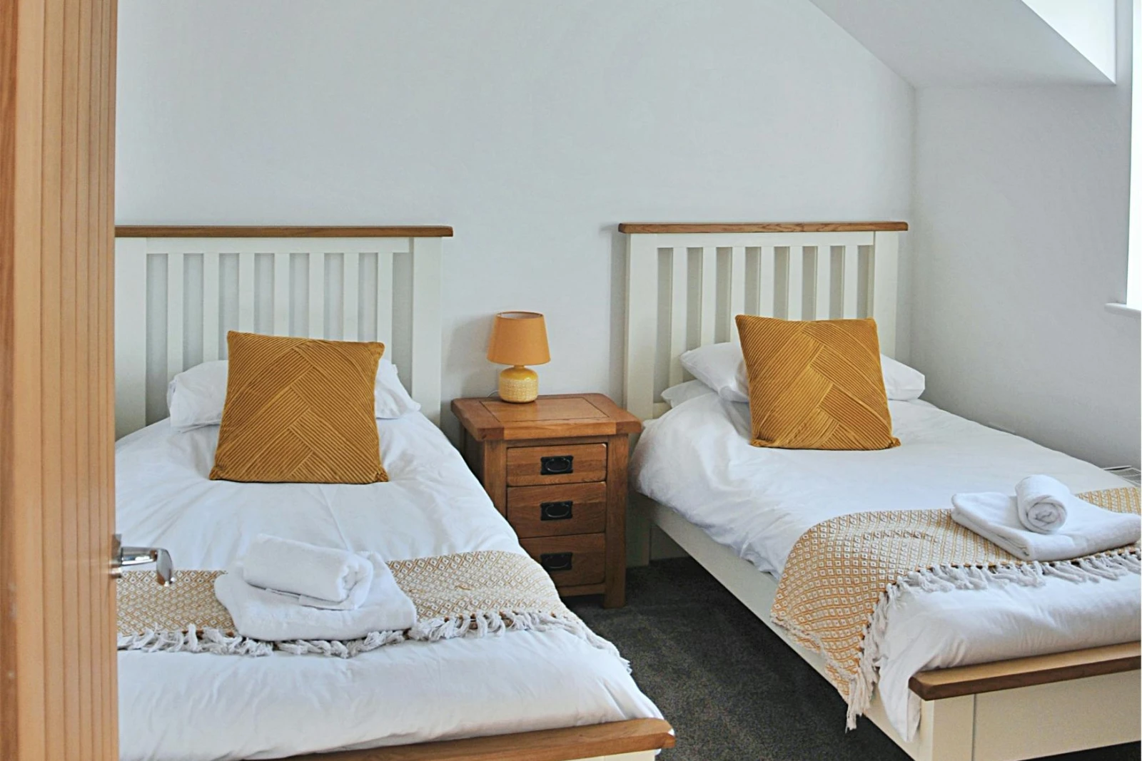 Twin beds with cushions and throws