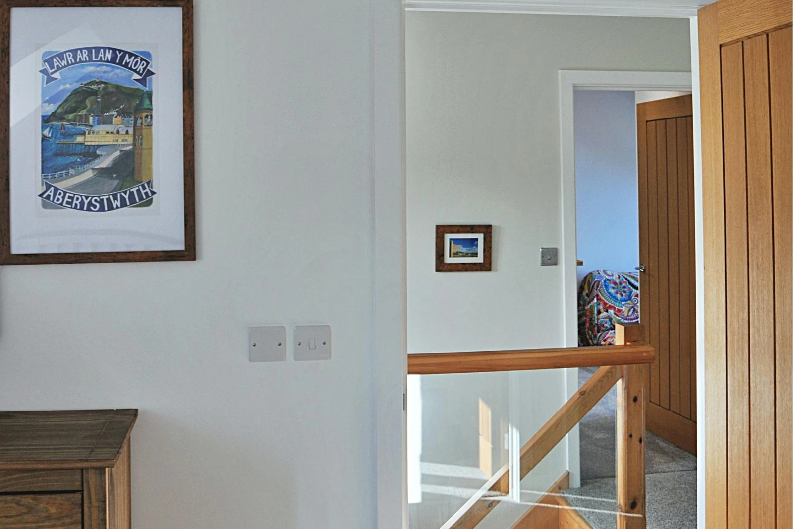 The landing area with glass panelled stairs