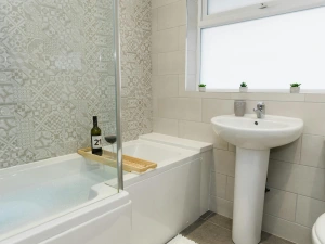 Bathroom with bath tub, sink basin and toilet.