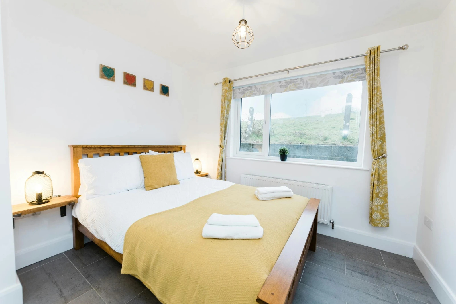 Bedroom with double bed, side table and lights.