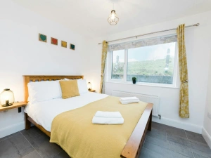 Bedroom with double bed, side table and lights.