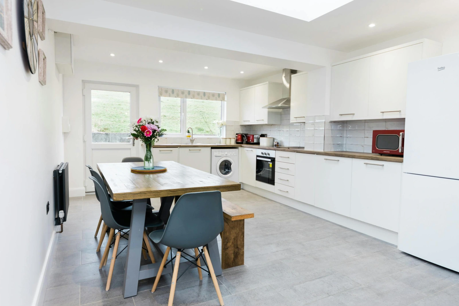 kitchen with dining table, matching cupboard units and appliances.