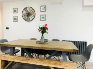 Dining table in the kitchen. flower vase on top.