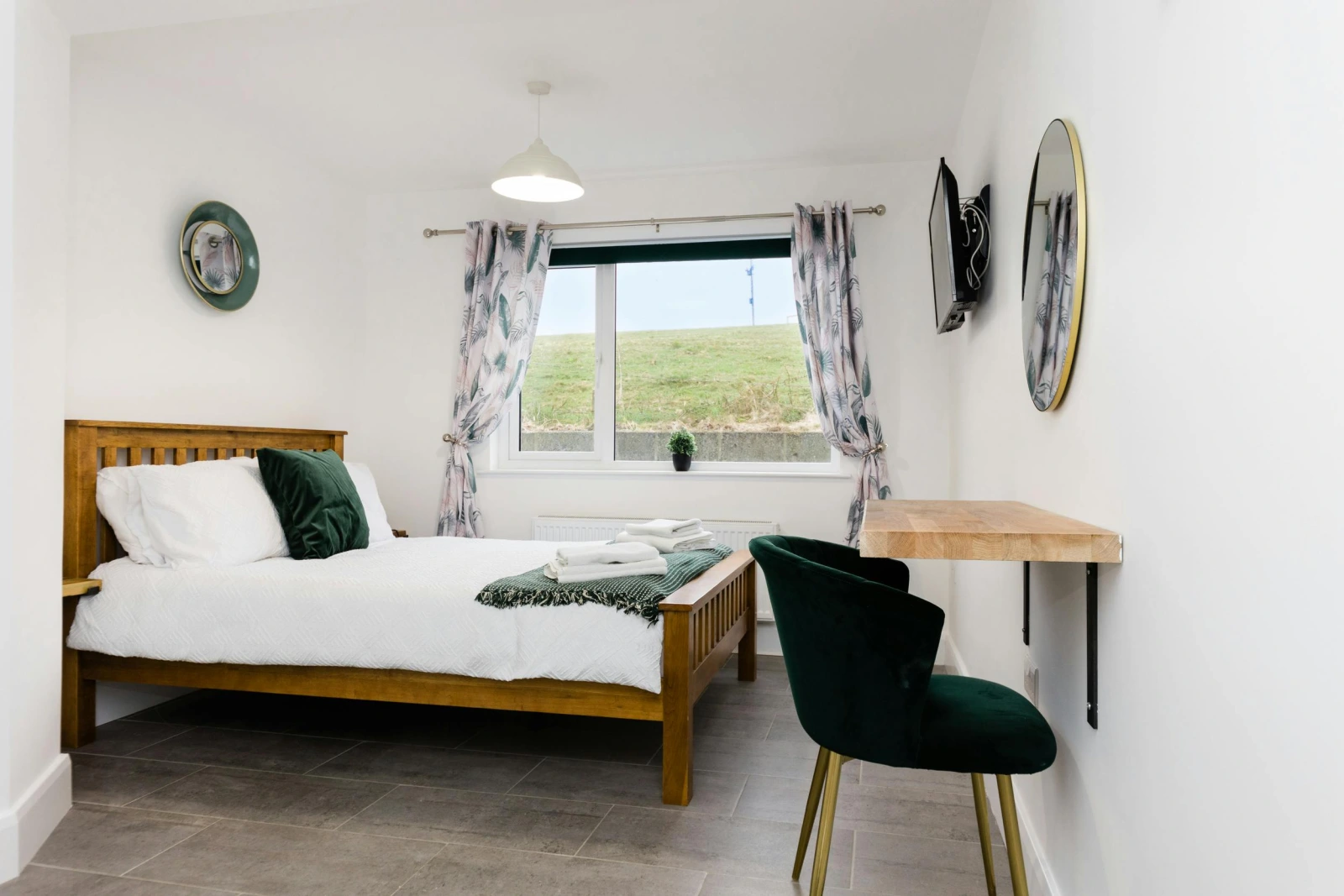 master bedroom with king bed, desk, clock and tv
