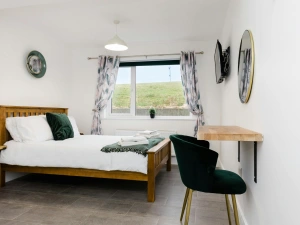 master bedroom with king bed, desk, clock and tv