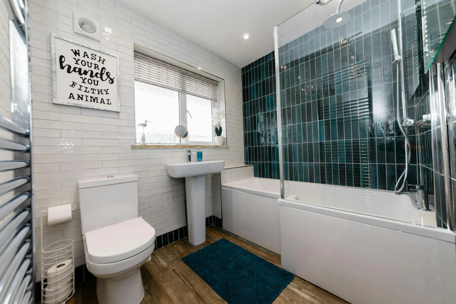 Bathroom with bath tub, shower, toilet, sink and towel warmer.
