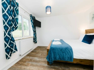 Bedroom with laminated wood flooring and wall mounted central heater.