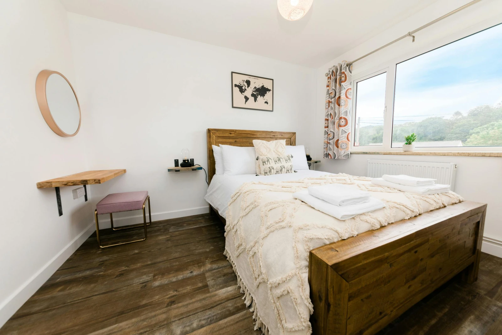 Bedroom with wooden single bed, desk and chair.