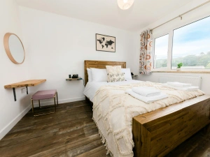 Bedroom with wooden single bed, desk and chair.