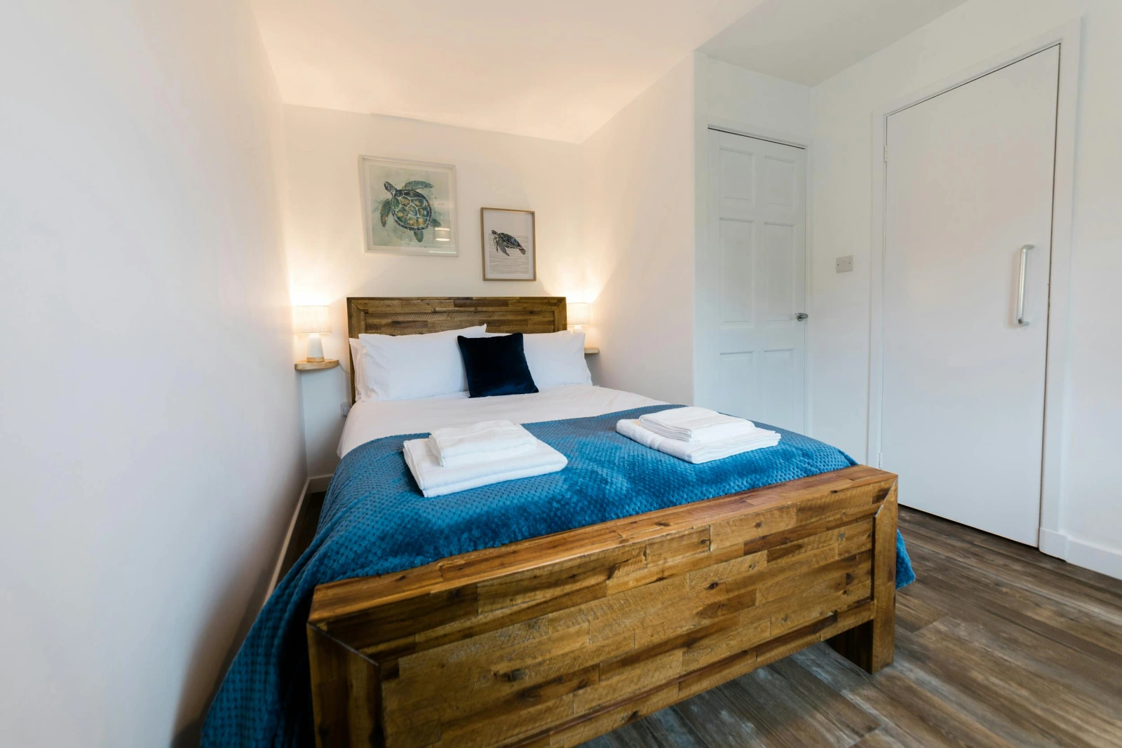 Bedroom with double bed, side table and light.