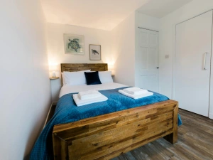 Bedroom with double bed, side table and light.