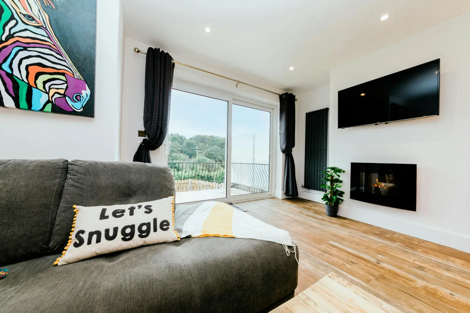 Living room with canvas painting, widescreen tv and laminated flooring.