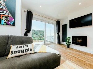 Living room with canvas painting, widescreen tv and laminated flooring.
