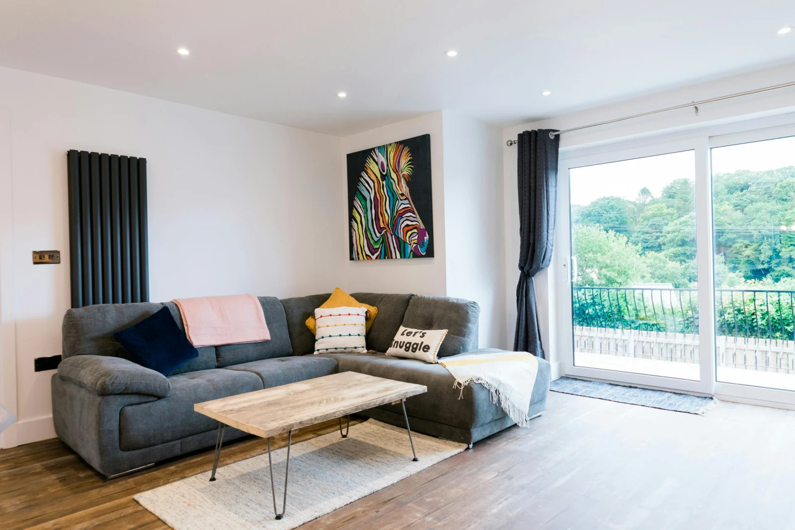 Living room with corner sofa. coffee table and sliding doors to outside.