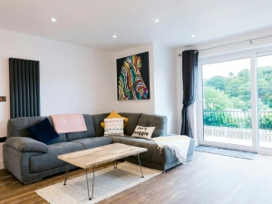 Living room with corner sofa. coffee table and sliding doors to outside.