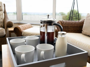 A tray in the conservatory with coffee, milk and mugs
