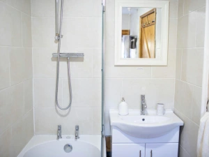 Fully lied bathroom. Bath with shower over and shower screen. Wash hand basin
