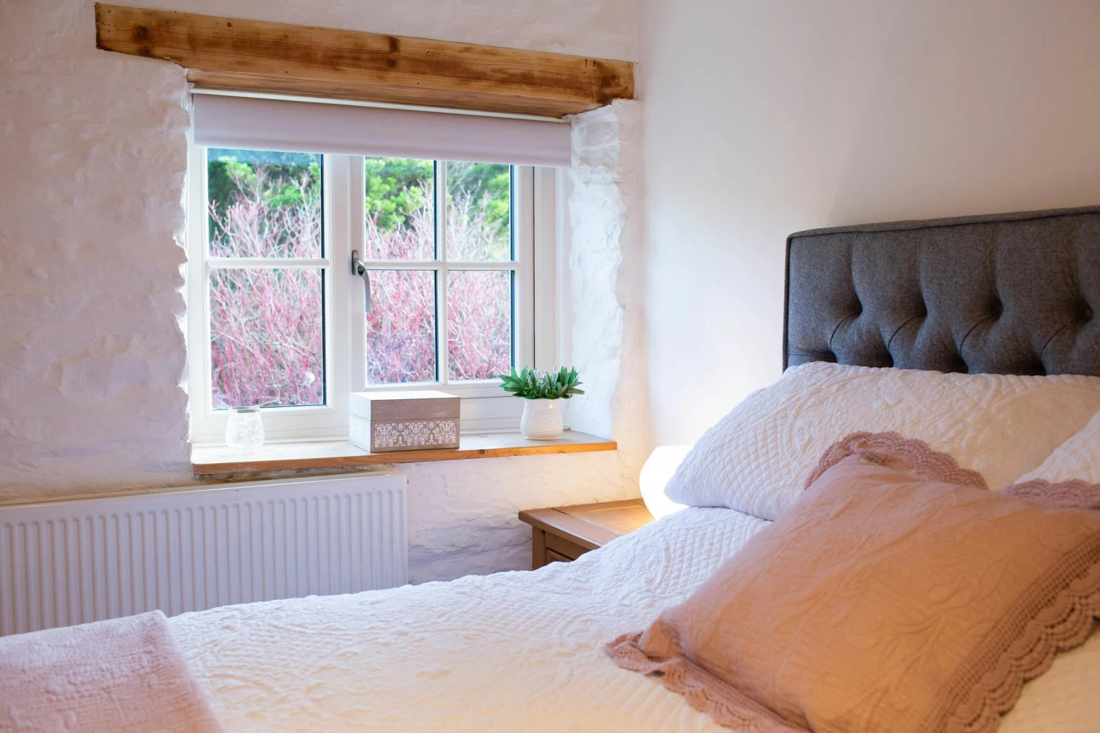 Kingsize bed with white bed linen and pink throw